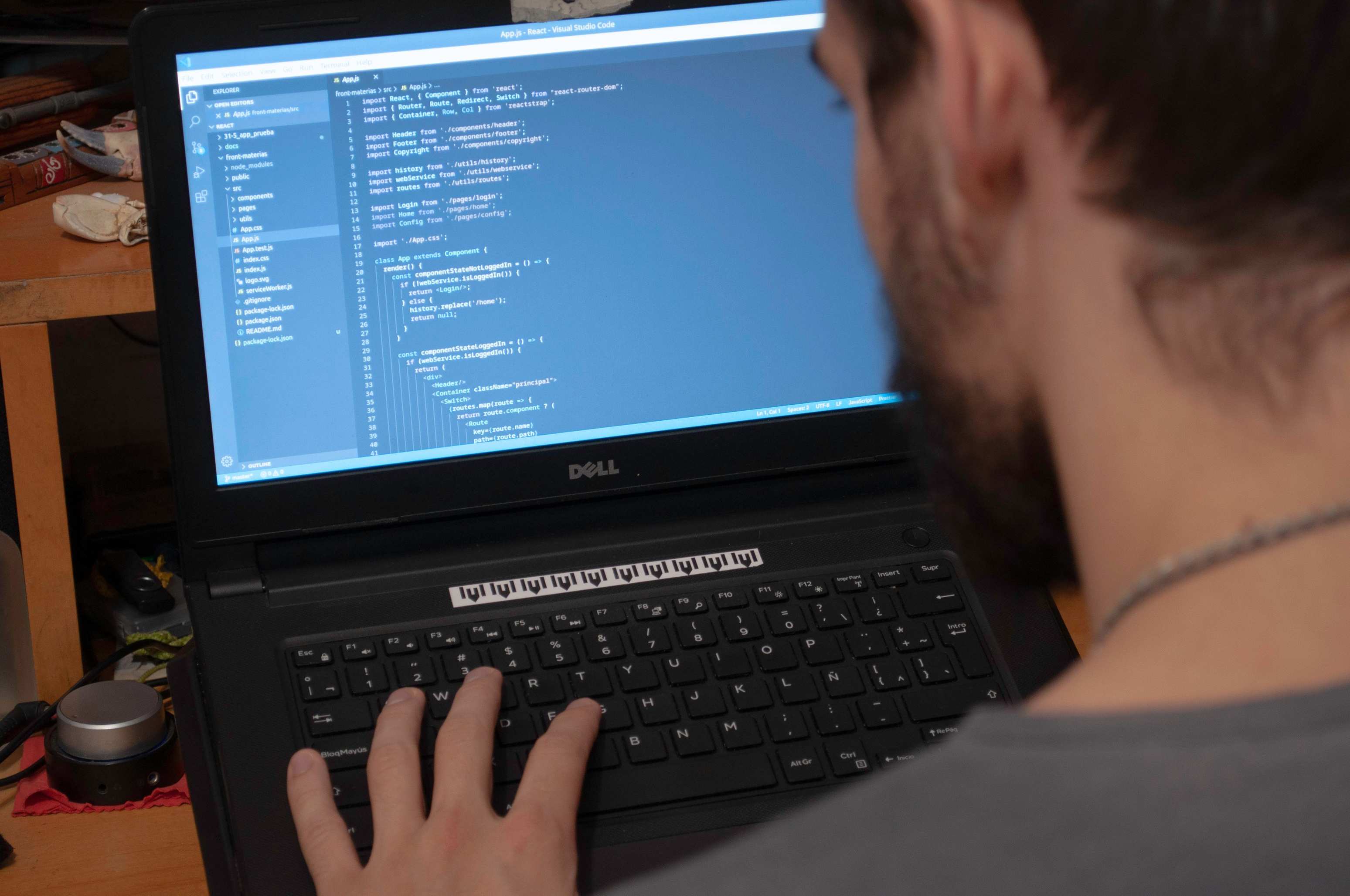 Hands typing on a laptop during software work, developer working on code in an office